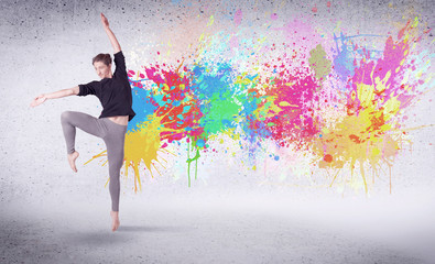 Obraz na płótnie Canvas Modern street dancer jumping with colorful paint splashes