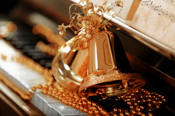 Piano keys decorated with golden Christmas decorations, close up