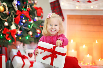 Fototapeta na wymiar Funny girl with gift boxes and Christmas tree on background
