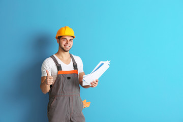 Young worker renewing apartment on wall background