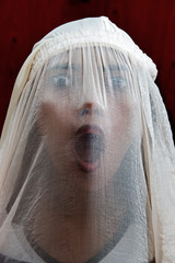 portrait of a girl screaming behind the veil
