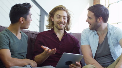 Student house accommodation. Flat share with young adults using digital tablet