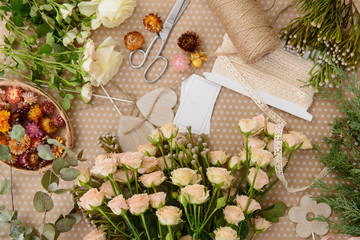 Florist workplace: flowers and accessories on the table. Top vie
