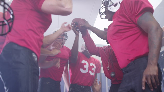  American football coach in locker room, psyching up players before the game
