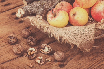 Fresh red ripe apples and  firewoods on wooden table
