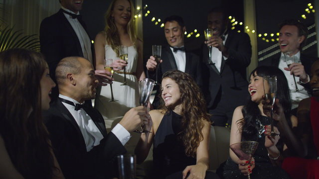  Happy group of friends at glamorous party, drinking champagne and celebrating