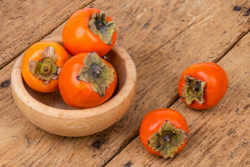 Fresh ripe persimmon on a wooden table - selective focus