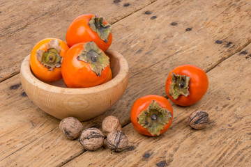 Fresh ripe persimmon on a wooden table - selective focus