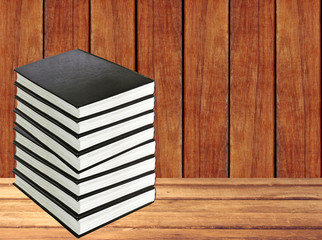stack of books on wooden table over wooden background
