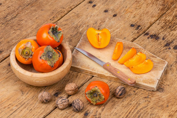 Fresh ripe persimmon on a wooden table - selective focus