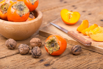 Fresh ripe persimmon on a wooden table - selective focus