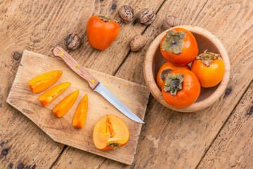Fresh ripe persimmon on a wooden table - selective focus