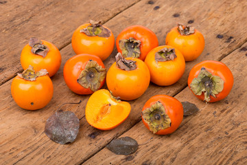 Fresh ripe persimmon on a wooden table - selective focus