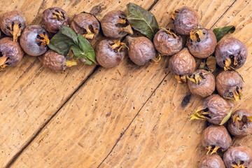 Healthy ripe Medlars on the old wooden table