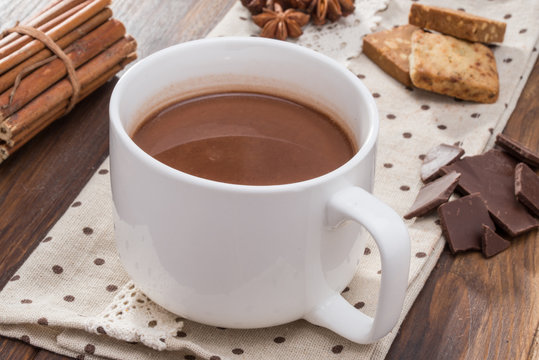 Mug filled with homemade hot chocolate, cookie with spice