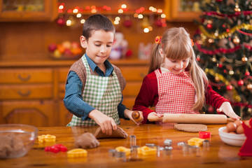 Obraz na płótnie Canvas two happy child preparing cookie for family dinner on Xmas eve