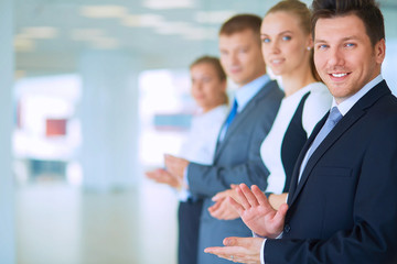 Smiling business people applauding a good presentation in the office