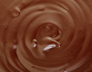 Melted dark chocolate flow, candy or chocolate preparation close-up as a background.