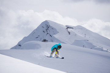 Flying snowboarder on mountains. Extreme sport.
