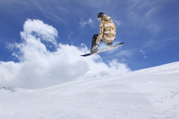 Flying snowboarder on mountains. Extreme sport.