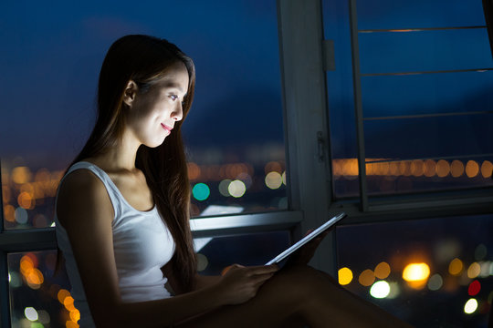 Woman use of the tablet pc at night