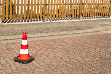 Eine Pilone steht auf einer Strasse aus Beton-Pflastersteinen