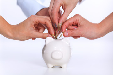 People putting coin into the piggy bank