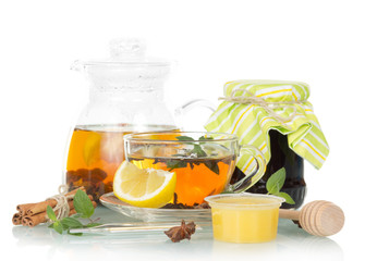 pot of tea with lemon, honey and jam on white