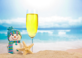 glass of champagne near a snowman on the beach