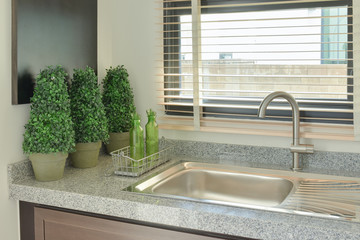 Sink with grey color counter top in the kitchen