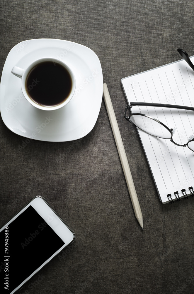 Wall mural smartphone with notebook and cup of coffee on wooden background