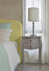 Fototapeta na wymiar Classic style bedside table with reading lamp next to cozy style