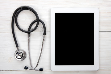 Tablet Computer With Blue Stethoscope on Wooden Background