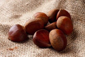 Heap of brown chestnuts on burlap