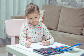 Naklejka premium Little girl is painting and drawing with pencil.