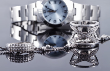 Silver rings and silver chain on the background of women's watch