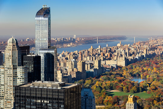 Aerial view of Central Park in autumn with Upper West Side in Manhattan, New York City. The view includes Midtown skyscrapers, the Hudson River and the George Washington Bridge.
