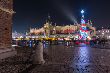 Obraz premium Krakow, Poland, Main Market square and Cloth Hall in the winter season, during Christmas fairs decorated with Christmas tree.