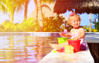Fototapeta na wymiar cute toddler girl playing in swimming pool at beach