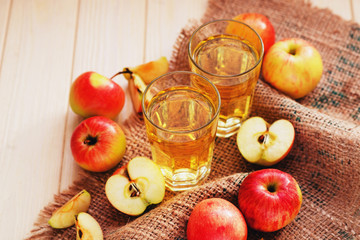 
apple cider with fresh apples , cinnamon , spices and chips on a wooden background