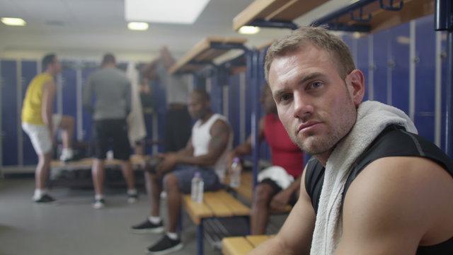  Portrait of serious man in gym locker room or sports team changing room