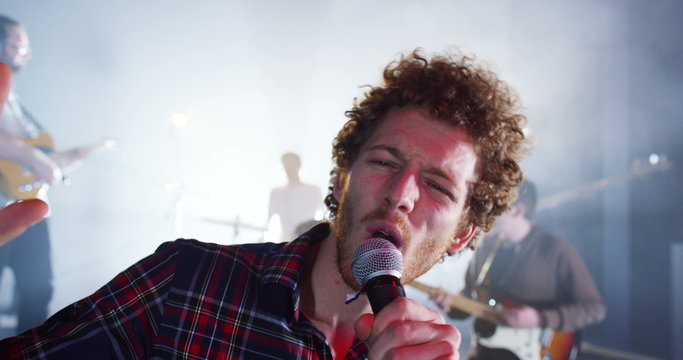 Attractive charismatic male singer performing with band at live music event