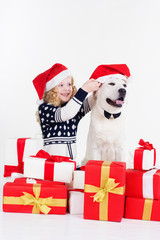 Child with labrador dog are wearing christmas hats