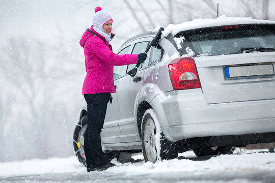 Woman Cleaning Her Car From Snow