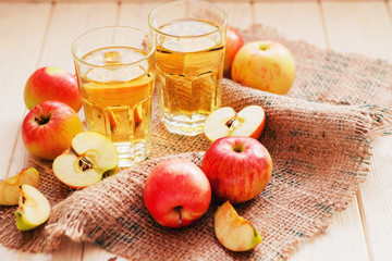 
apple cider with fresh apples , cinnamon , spices and chips on a wooden background