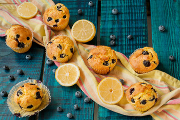 Muffins
Delicious muffins with blueberries. Decorated with fresh blueberries and lemon. Summer dessert on a blue background, which is stylized under the old board.