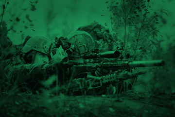 snipers in camouflage suit standing with arms and looking at the target