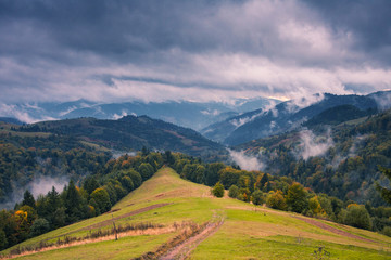 Cloudy autumn day in mountains . Green hills . Fairy landscape .