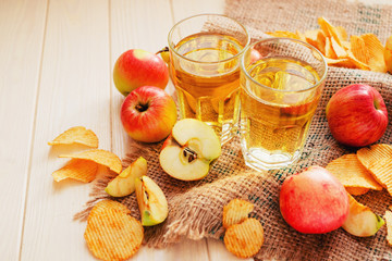 
apple cider with fresh apples , cinnamon , spices and chips on a wooden background