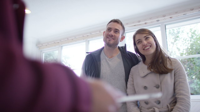  Young couple with real estate agent, looking at home to buy or rent